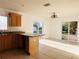 Kitchen with wood cabinets, granite counters, and view to backyard at 3400 Rain Lily, Englewood, FL 34224