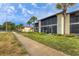 Condo building exterior, showcasing landscaping and walkway at 391 Airport E Ave # 403, Venice, FL 34285