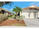 Villa with tile roof, two-car garage, and mature landscaping at 4259 Whispering Oaks Dr, North Port, FL 34287