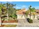 Single-story villa with tile roof, two-car garage, and landscaped yard at 4259 Whispering Oaks Dr, North Port, FL 34287
