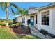 Welcoming villa entry with teal door and landscaping at 4259 Whispering Oaks Dr, North Port, FL 34287