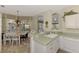 Kitchen with a breakfast bar, white cabinets, and a view to a casual dining area at 4259 Whispering Oaks Dr, North Port, FL 34287