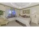 Spacious main bedroom with a king-size bed, a ceiling fan, and a sitting area at 4259 Whispering Oaks Dr, North Port, FL 34287