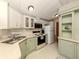 Galley-style kitchen with white and light green cabinets and stainless steel sink at 43 Crown Point Dr, Nokomis, FL 34275