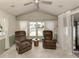 Relaxing living area with two brown recliners and a view of the outdoors through large windows at 43 Crown Point Dr, Nokomis, FL 34275