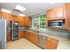 Bright community kitchen featuring stainless steel appliances and wood cabinets at 430 Marsh Creek Rd, Venice, FL 34292