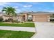 Tan house with tile roof, landscaping, and a circular driveway at 430 Marsh Creek Rd, Venice, FL 34292