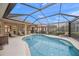 Inviting pool area with screened enclosure, lounge chairs, and patio furniture at 430 Marsh Creek Rd, Venice, FL 34292