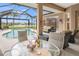 Spacious poolside patio with seating and dining area, overlooking the lake at 430 Marsh Creek Rd, Venice, FL 34292
