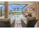 Peaceful poolside patio with wicker seating and lake view at 430 Marsh Creek Rd, Venice, FL 34292