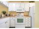 Kitchen with white cabinets, microwave, and electric range at 458 Cerromar Rd # 483, Venice, FL 34293