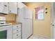 White kitchen features ample cabinetry and a refrigerator at 458 Cerromar Rd # 483, Venice, FL 34293