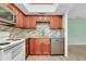Modern kitchen with wood cabinets, granite counters, and white appliances at 460 Base E Ave # 122, Venice, FL 34285