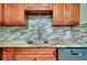 Modern kitchen with wood cabinets, granite counters, and stainless steel sink at 460 Base E Ave # 122, Venice, FL 34285