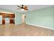 Open living room and kitchen area with laminate floors and ceiling fan at 460 Base E Ave # 122, Venice, FL 34285