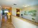 Bright entryway with tile floors, kitchenette peek, and tropical wall mural at 500 The Esplanade N # 306, Venice, FL 34285