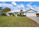 Single-story home with white exterior, landscaping, and a paved driveway at 545 Warwick Ln, Venice, FL 34293