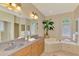 Elegant bathroom with double vanity and a relaxing bathtub at 5561 White Ibis Dr, North Port, FL 34287