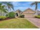 House exterior with attractive landscaping and brick paver driveway at 5561 White Ibis Dr, North Port, FL 34287