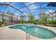 Refreshing kidney-shaped pool with spa and screened enclosure at 5561 White Ibis Dr, North Port, FL 34287