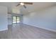 Spacious living room with light walls, ceiling fan, and wood-look floors at 6670 Harmony Rd, North Port, FL 34287