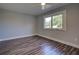 Simple bedroom with wood-look floors and a window at 6700 Harmony Rd, North Port, FL 34287