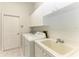 Laundry room with washer, dryer, cabinets, and utility sink at 7023 Chickasaw Bayou Rd, Bradenton, FL 34203