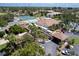 Aerial view of the community featuring a pool, tennis courts, and lush landscaping at 752 White Pine Tree Rd # 108, Venice, FL 34285