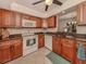 Kitchen with wood cabinets, granite counters, and white appliances at 806 Capri Isles Blvd # 109, Venice, FL 34292