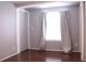 Bedroom with large window, closet, and wood flooring at 808 S Green Cir, Venice, FL 34285