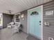 Front porch with white wicker chairs and a teal front door at 842 Linden Rd, Venice, FL 34293