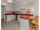 Kitchen with red countertops, white cabinets, and stainless steel appliances at 842 Linden Rd, Venice, FL 34293