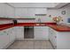 Kitchen with red countertops, white cabinets, and stainless steel appliances at 842 Linden Rd, Venice, FL 34293