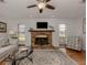 Living room with brick fireplace, hardwood floors, and comfy seating at 842 Linden Rd, Venice, FL 34293