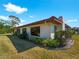 Side view of single story home with red tile roof, white walls, and manicured landscaping at 854 Senda Plata # 22, Venice, FL 34293