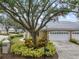 Tan house with a two-car garage and mature tree in front at 900 Paisley Ct # 1, Venice, FL 34293