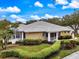 Tan one-story home with tile roof, screened lanai, and lush landscaping at 900 Paisley Ct # 1, Venice, FL 34293