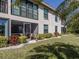 Ground-level condo showcasing a screened patio, manicured lawn, and lush landscaping at 936 Capri Isles Blvd # 102, Venice, FL 34292