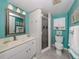Clean bathroom with teal walls, white vanity, and a walk-in shower at 936 Capri Isles Blvd # 102, Venice, FL 34292