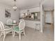 Dining area with glass-top table, white chairs, and kitchen pass-through at 936 Capri Isles Blvd # 102, Venice, FL 34292