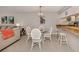 Dining area with glass-top table, white chairs, and kitchen pass-through at 936 Capri Isles Blvd # 102, Venice, FL 34292