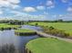 Elevated view of a peaceful golf course with a bridge and water at 936 Capri Isles Blvd # 102, Venice, FL 34292