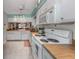 Open kitchen with white cabinets, wood countertops, and a view of the living area at 936 Capri Isles Blvd # 102, Venice, FL 34292
