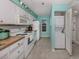 Efficient kitchen with white cabinets, wood countertops, and stackable washer/dryer at 936 Capri Isles Blvd # 102, Venice, FL 34292