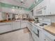 Open kitchen with white cabinets, wood countertops, and a view of the living area at 936 Capri Isles Blvd # 102, Venice, FL 34292
