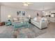 Bright living room with light beige sofas, teal accents, and coastal decor at 936 Capri Isles Blvd # 102, Venice, FL 34292