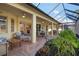 Relaxing covered patio featuring a brick paved surface and lush landscaping at 1014 Tuscany Blvd, Venice, FL 34292