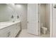 Bathroom with double vanity, white cabinets, toilet in separate room and large mirror at 11842 Sistine Ln, Venice, FL 34293