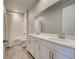 Bathroom with double vanity, large mirror and a tub with a shower at 11842 Sistine Ln, Venice, FL 34293