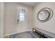 Bright foyer featuring a decorative front door, stylish round mirror, and bench with shoe rack at 11842 Sistine Ln, Venice, FL 34293